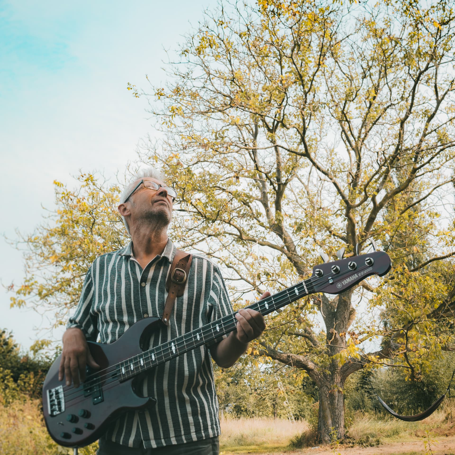 Lo Meulen playing bass beneath a walnut tree